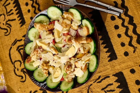 Salade Owazi — jeunes pousses de laitue, escalopes de poulet effilochées, parmesan et croûtons, saveurs afro-françaises — Mauya Lyon