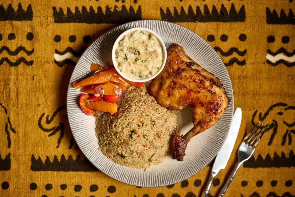 Tchep poulet — thieboudienne ivoirien revisité : poulet grillé, riz parfumé aux épices d'Afrique de l'Ouest, sauce crémeuse, dressage bistronomique — Mauya Lyon